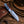 Retained farrier rasp file teeth across the flat of a mirror-polished cowboy knife blade