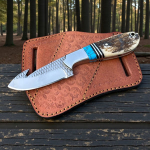 Knife with wooden handle and leather sheath on a wooden surface with a forest background