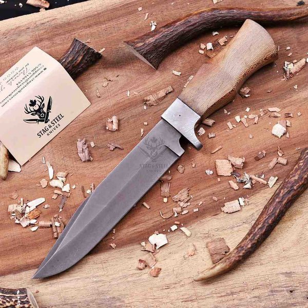 Full profile of stonewashed D2 full tang hunting knife with lacewood handle on board