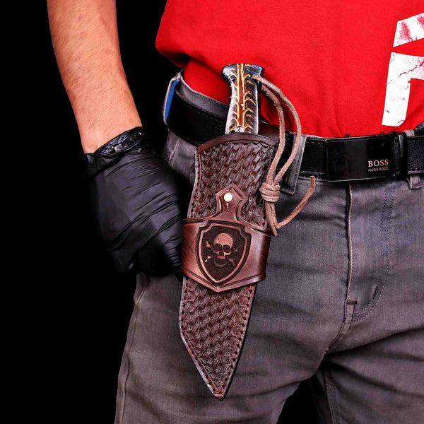 Damascus tanto knife worn vertically in skull-engraved sheath