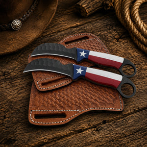 Two fixed-blade knives with Texas flag handle designs rest on a brown leather sheath over a rustic wooden surface, with a cowboy hat and rope partially visible in the background.