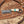 Handcrafted knife with a decorative handle on a wooden surface with wood shavings.
