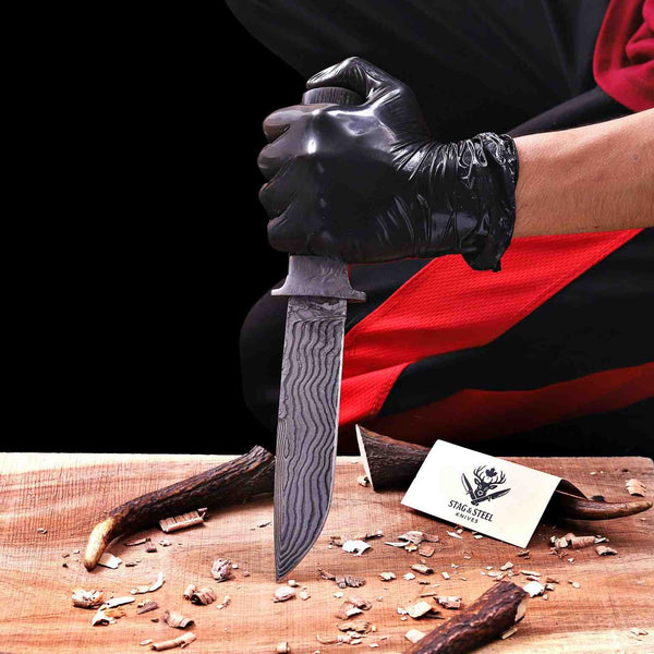 Top-down flat lay of VG10 Damascus hunting knife on workbench with shavings