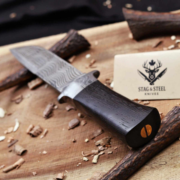 Close-up of dark wenge wood grain on Damascus hunting knife handle
