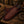 Brown leather boot jack with intricate pattern on a wooden surface with rope and horseshoe.