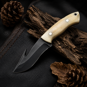 A fixed-blade knife with an ivory-colored handle and black blade 