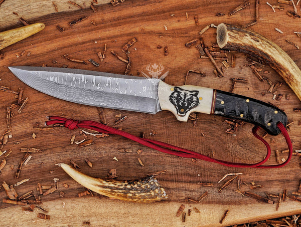 Hunting knife with detailed wolf design engraved handle