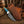 Knife with turquoise handle and Damascus blade in a brown leather sheath on a wooden surface.