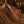 Brown leather boot jack with blue handle on a wooden surface with cowboy hat, gloves, and rope.